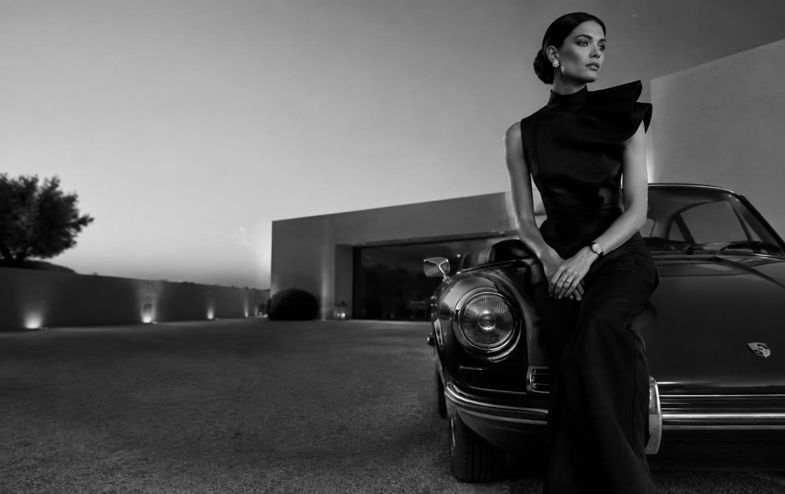 Editorial fashion portrait with a classic sports car at a luxury residence